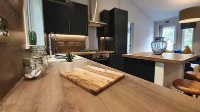 a kitchen with a wooden cutting board on a table at High Spy Luxury Lodge in Keswick