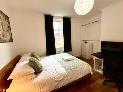 a small bedroom with a bed and a television at Clapham Road Apartment in Moffat