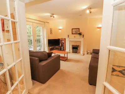 a living room with a couch and a fireplace at Flat 17 Greta Grove in Keswick