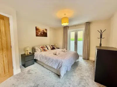 a bedroom with a large bed and a television at Jaytrees, Keswick - Luxury bungalow with hot tub in Keswick