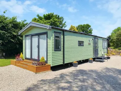 a green tiny house sitting on a gravel lot at Melfell View - Uk50086 in Penruddock