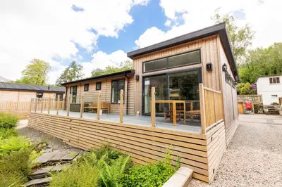 a tiny house with a large window on the deck at Great Gable Riverside Luxury Lodge in Keswick