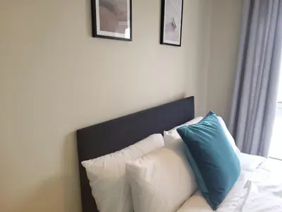 a white couch with blue pillows in a room at The MacIntyre - Coorie Doon Stays in Kilmarnock