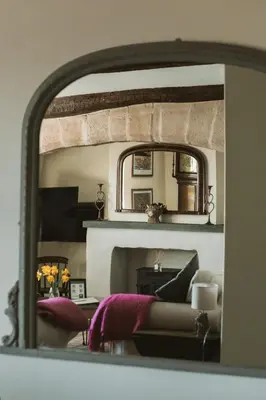 a living room with a couch and a mirror at The Farmhouse at Highside Farm in Bassenthwaite
