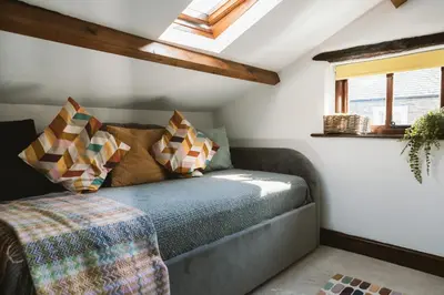 a bed in a room with a window and a couch at The Farmhouse at Highside Farm in Bassenthwaite