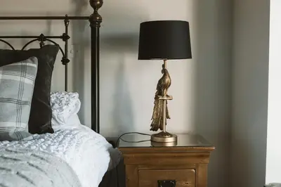 a lamp on a table next to a bed at The Farmhouse at Highside Farm in Bassenthwaite