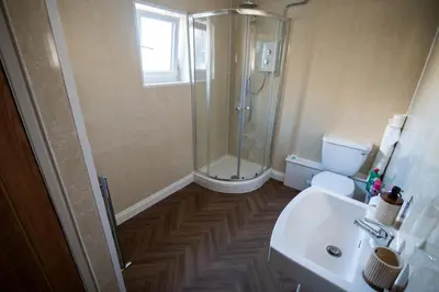 a bathroom with a shower and a toilet and a sink at Cottage in Seaton in Siddick