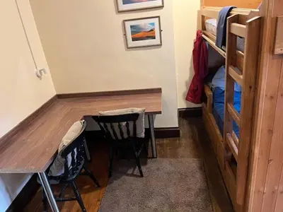 a room with a desk and a bed and a table and chairs at The White Hart Inn & Bunkhouse in Moffat