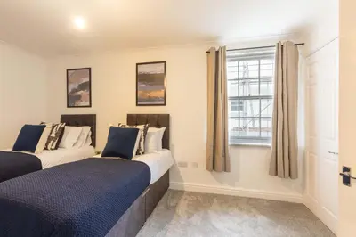 two beds in a room with a window at Lovely 2BED Whitehaven Apartment with Sea Views in Whitehaven