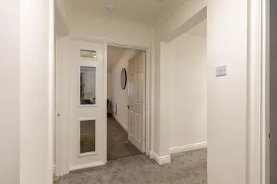 a hallway with white walls and an open door at Lovely 2BED Whitehaven Apartment with Sea Views in Whitehaven