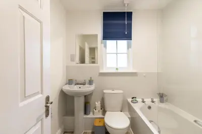 a white bathroom with a toilet and a sink at Lovely 2BED Whitehaven Apartment with Sea Views in Whitehaven