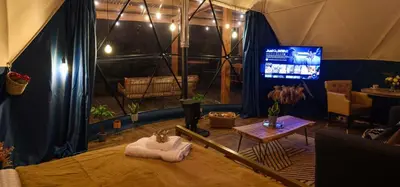 a room with a cat laying on a bed in a tent at Coorie Retreats Luxury Geo Domes and Cabins with Private Hot Tubs Cinema Firepit Spa and More in Portpatrick