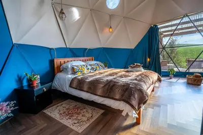 a bedroom with a bed in a tent at Coorie Retreats Luxury Geo Domes and Cabins with Private Hot Tubs Cinema Firepit Spa and More in Portpatrick