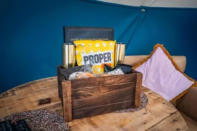 a wooden table with a box of food on it at Coorie Retreats Luxury Geo Domes and Cabins with Private Hot Tubs Cinema Firepit Spa and More in Portpatrick