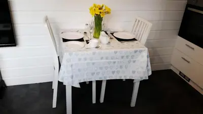 a table with two chairs and a vase with yellow flowers at Mountain Lodge, Lake View, National Park in Borrowdale Valley