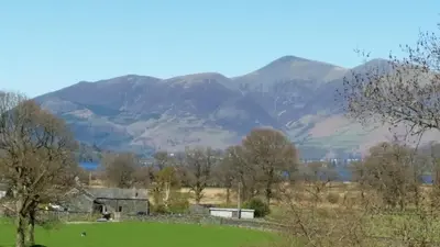 a view of a field with mountains in the background at Mountain Lodge, Lake View, National Park in Borrowdale Valley
