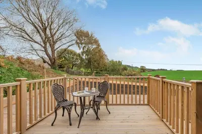 two chairs and a table on a wooden deck at 2 Bed in Mouswald oc-b33444 in Mouswald