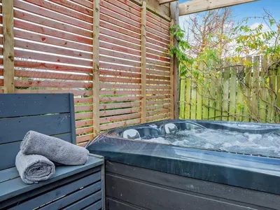 a hot tub sitting next to a wooden fence at 1 Bed in Dearham 96373 in Dearham
