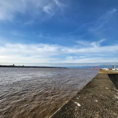 a large body of water with a wooden pier at Riverside Apartment in Moffat