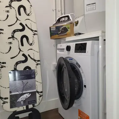 a washing machine in a room with a snowboard at Riverside Apartment in Moffat