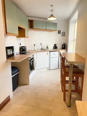 a kitchen with a table and a dining room at Hadrians Retreat, Cosy 1 Bed Flat - near M6 Jct45, A75, Gretna & Carlisle in Longtown