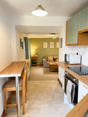 a kitchen and living room with a table and a couch at Hadrians Retreat, Cosy 1 Bed Flat - near M6 Jct45, A75, Gretna & Carlisle in Longtown