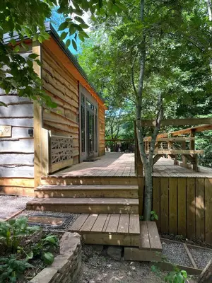 a log cabin with stairs leading to a door at Ty Cwtch Cabin - secluded woodland cabin & covered hot tub in Moffat
