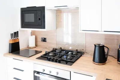 a kitchen with a stove and a microwave at Ardwall in Carsluith