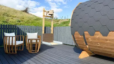 a wooden deck with two chairs and a basketball hoop at Ardwall in Carsluith