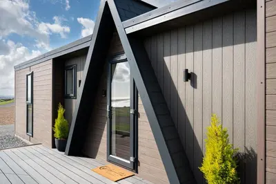 a timber clad house with a wooden deck at Ardwall in Carsluith