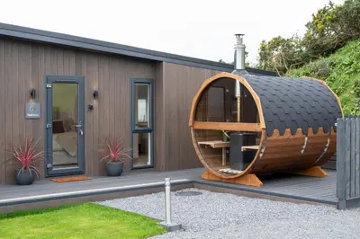 a small house with a wooden circle on a deck at Barlocco in Carsluith