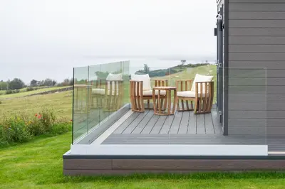 a deck with chairs and a table on a house at Barlocco in Carsluith