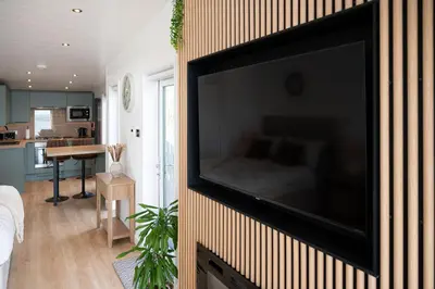 a flat screen tv hanging on a wall in a living room at Barlocco in Carsluith