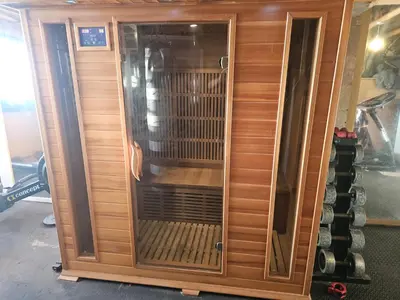 a wooden entertainment center with a glass door at Sandylands in Braystones