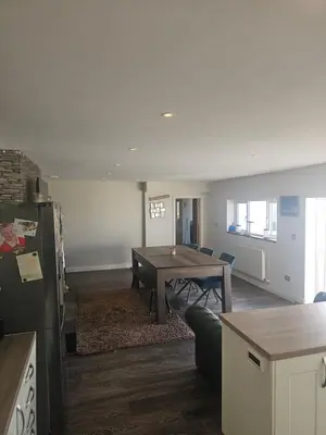 a kitchen and living room with a table and a couch at Sandylands in Braystones