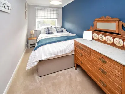 a bedroom with a large bed and a wooden dresser at Quarry's Edge in Chapel Stile