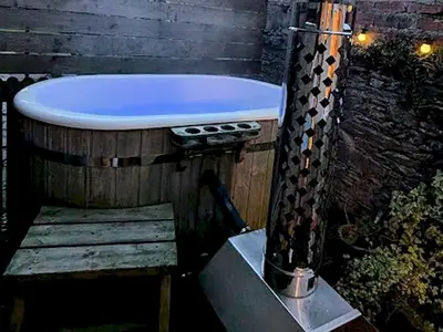 a bath tub sitting on top of a wooden table at Pass the Keys Cosy Romantic Getaway with Hot Tub in Whithorn