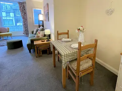 a living room with a table and a couch at Pass the Keys Cosy Romantic Getaway with Hot Tub in Whithorn