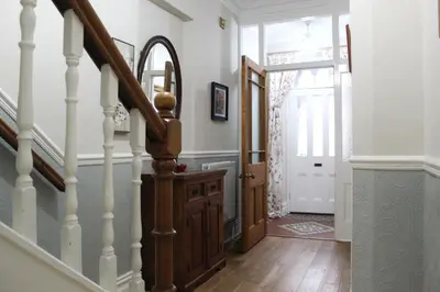 a hallway with a stairway with a wooden stair case at Sunnycroft - Hot tub hire available, fitness centre, free parking in Keswick