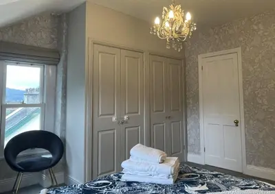 a pile of towels on a table in a room with a chandelier at Sunnycroft - Hot tub hire available, fitness centre, free parking in Keswick