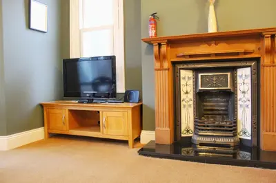 a living room with a tv and a fireplace at Sunnycroft - Hot tub hire available, fitness centre, free parking in Keswick