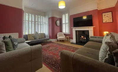 a living room with two couches and a fireplace at Sunnycroft - Hot tub hire available, fitness centre, free parking in Keswick