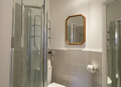 a bathroom with a shower and a mirror at Sunnycroft - Hot tub hire available, fitness centre, free parking in Keswick