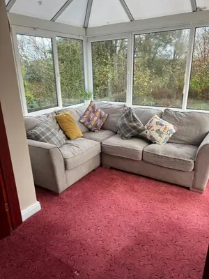 a couch with pillows sitting in a room with windows at The Holm in Canonbie