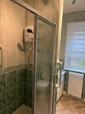 a shower with a glass door in a bathroom at The Holm in Canonbie