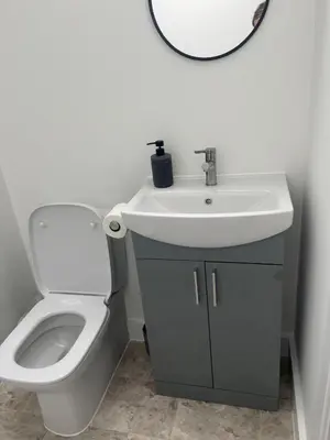 a bathroom with a sink and a toilet and a mirror at Oak Field View - Self Contained Studio in Scotby