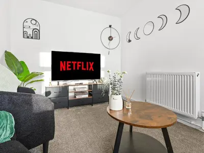 a living room with a tv and a table at Edison House - Comfy Stay in Stafford in Moffat