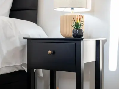 a black bedside table with a lamp and a plant on it at Edison House - Comfy Stay in Stafford in Moffat