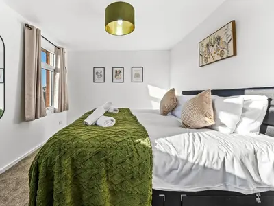 a bedroom with a large bed with a green blanket at Edison House - Comfy Stay in Stafford in Moffat