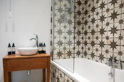 a bathroom with a bath tub and a sink at Victorian House in Grasmere